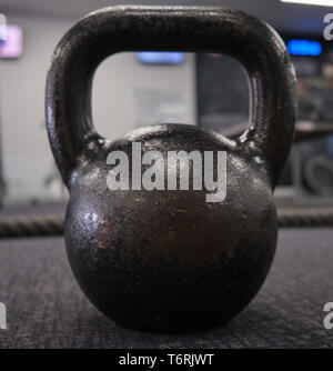 Schwarz kettlebell große Nähe von hinten in der Turnhalle auf dem Teppich boden aufrecht Stockfoto