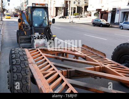 Auf eine Stadt Straße der Traktor mit einer Düse für die Reparatur von Schäden, die auf Asphalt wurde entladen Stockfoto