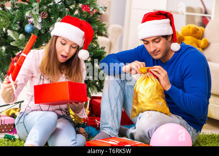 Junges Paar Weihnachten zu Hause feiern. Stockfoto
