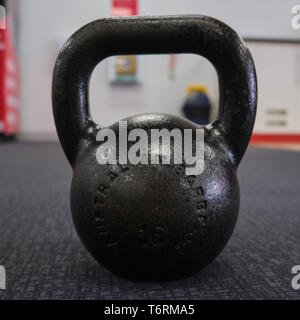 Schwarz kettlebell große Nähe von vorne auf dem Teppich boden einer Turnhalle Stockfoto