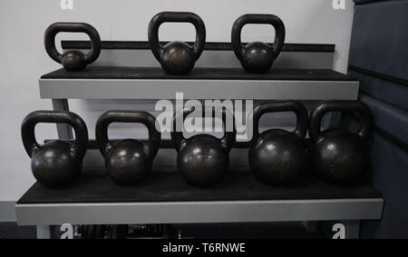 Kettlebells 8 übersichtlich geordnet in einem Rack in einem Fitnessstudio, alle schwarz Stockfoto