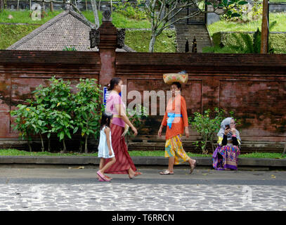 Frau wandern in Sarong mit einem Korb auf dem Kopf, das zweimal jährlich erscheinende Mode-Special heiligen Tempel, Ubud, Bali, Indonesien Stockfoto