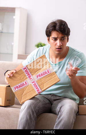 Mann öffnen zerbrechliches Paket aus dem Internet bestellt Stockfoto