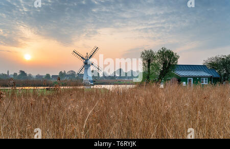 Sonnenaufgang über thurne Mühle vom Ufer des Flusses auf der Norfolk Broads Stockfoto