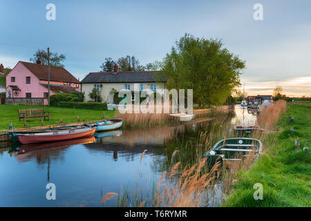 Abendlicht über Boote, die von hübschen Cottages günstig bei West Somerton auf der Norfolk Broads Stockfoto