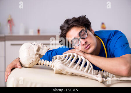 Lustige Arzt mit Skelett im Krankenhaus Stockfoto