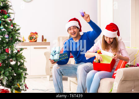 Junges Paar Weihnachten zu Hause feiern. Stockfoto