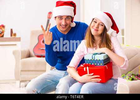 Junges Paar Weihnachten zu Hause feiern. Stockfoto