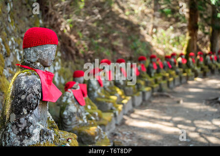 Berühmten Stein und roten Kanmangafuchi Jizo Statuen in den Abgrund, Nikko, Tochigi in Japan mit Hüten, viele Abbildungen zum Schutz der Toten Stockfoto