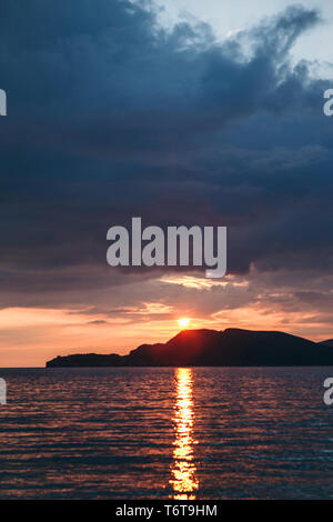 Schöne Aussicht auf den Sonnenuntergang und Sonnenaufgang und die natürliche Landschaft mit dem Meer und den Hügeln oder Bergen in Montenegro im Sommer. Stockfoto