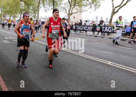 London, England - 28. April 2019: ein Blinder mit seinem Führer in die letzte Meile der Virgin Money London Marathon. Stockfoto