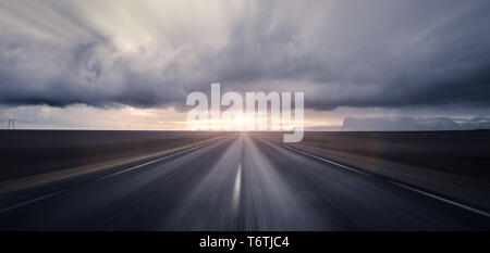 Straße in Richtung Sonnenuntergang mit Motion blur Effekt führenden Stockfoto