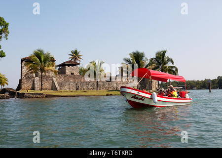 Mittelamerika Tourismus - Touristen auf einer Bootsfahrt auf dem Rio Dulce mit dem Castillo de San Felipe de Lara, Izabal See Guatemala Mittelamerika Stockfoto