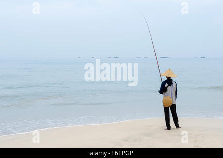 Ein lokaler Mann angeln am Jimbaran Beach auf Bali, Indonesien Stockfoto