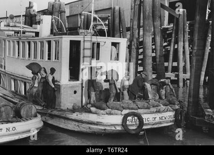 Foto von Afrikanische amerikanische Männer entladen schwere Säcke mit Austern aus ein Paket Boot Dock, New Orleans, Louisiana, 1935. Von der New York Public Library. () Stockfoto