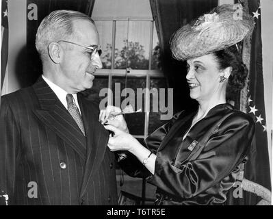 Close-up Profil ansehen, von der Taille bis, von Frau Walter G Craven, nationaler Präsident der American Legion Auxiliary, Pinning einer Mohnblume, Präsident Harry Truman's Revers, Washington, DC, 29. April 1946. Mit freundlicher Genehmigung der nationalen Archive. () Stockfoto