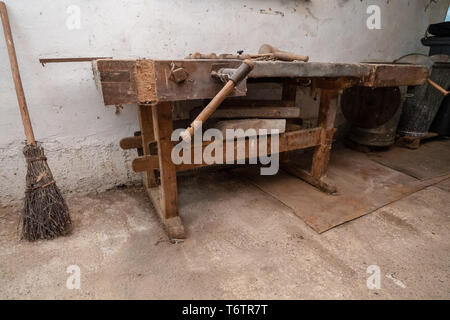 Traditionelle Besen neben einem alten Workbench von einem Zimmermann in seiner Werkstatt in der alpinen Region in Österreich Stockfoto