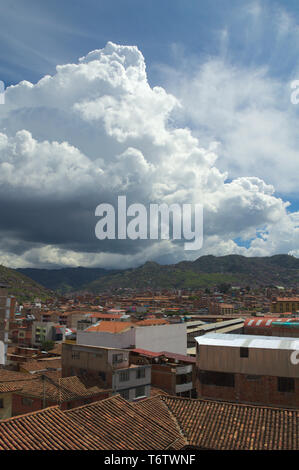 Blick über die Dächer in Cusco, Peru. Eine enorme Cumulus cloud Webstühle über die Stadt. Stockfoto