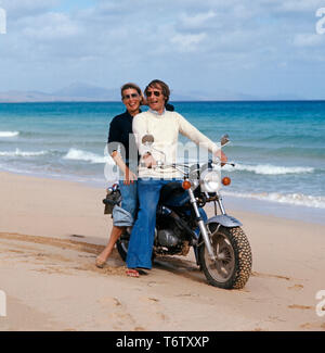 Der Prinz von Preußen, Michael sitzt mit seiner Ehefrau Brigitta auf einem Motorrad von Suzuki in am Strand von Mallorca auf den 1970er Jahren. Der Prinz von Preußen, Michael und seine Frau Brigitta sind auf einem Motorrad von Suzuki auf Mallorca auf die 1970er Jahre. Stockfoto