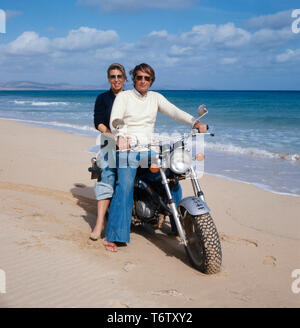 Der Prinz von Preußen, Michael sitzt mit seiner Ehefrau Brigitta auf einem Motorrad von Suzuki in am Strand von Mallorca auf den 1970er Jahren. Der Prinz von Preußen, Michael und seine Frau Brigitta sind auf einem Motorrad von Suzuki auf Mallorca auf die 1970er Jahre. Stockfoto