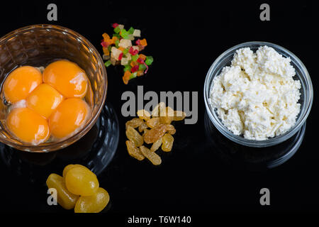 Hellgelb Eigelb in eine Glasschüssel auf schwarzem Hintergrund. Zutaten für Küche leckere Gerichte. Stockfoto