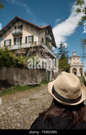 Reisende Mädchen mit Vintage Strohhut monumets suchen und eine der XIVchapel entlang dem Weg der historischen Pilgerweg zum heiligen Berg oder Sa Stockfoto