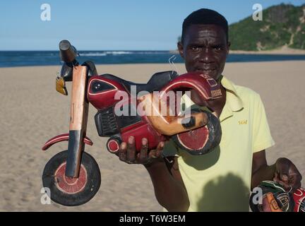 Mann verkaufen Holz- Motorrad Carven auf Ponta do Ouro Beach, Mosambik Stockfoto