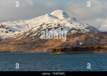 Dutch Harbor, Alaska - 23. April 2016. Foto von Dutch Harbor, einer Hafenstadt in Alaska; er sitzt am Fuße der schneebedeckten Berge. Stockfoto