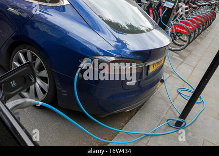 Eine blaue Tesla Model S Auto lädt seine Batterien von einer Straße Aufladen von Zahlen - Polar Netzwerk von einem Elektrobay-ladestation Point in St. James's Square, am 29. April 2019 in London, England. Stockfoto