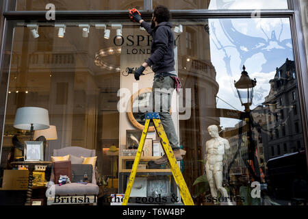 Oben eine Statue des antiken griechischen Gott Apollo, ein Vertrag Glasreiniger Tücher Fenster Glas Osprey in der Regent Street, am 2. Mai 2019 in London, England. Stockfoto