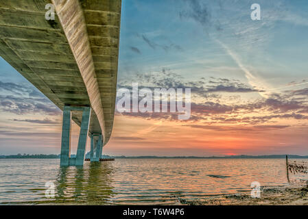 Die Unterseite der Kronprinzessin Mary Bridge, und die Sonne und die roten Wolken sind im Wasser, Frederikssund, Dänemark, 30. April 2019 widerspiegeln Stockfoto