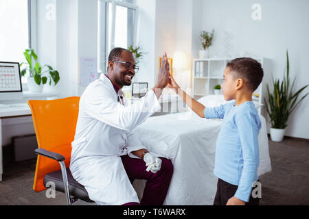 Cute boy hohe Fünf angenehme professionelle Kinderarzt Stockfoto