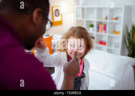 Schöne lockige Mädchen Berühren der Nase ihrer fürsorglichen liebevollen Vater Stockfoto