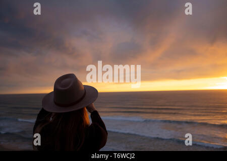 Frau suchen an der szenischen Ozean Sonnenuntergang Stockfoto