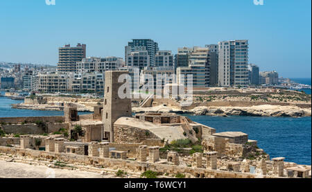 Historisch und modern Seite an Seite in Malta. Die Kalksteinfestungen St. Elmo und Tigné stehen im Kontrast zu den modernen Wohnblocks von Sliema. Stockfoto