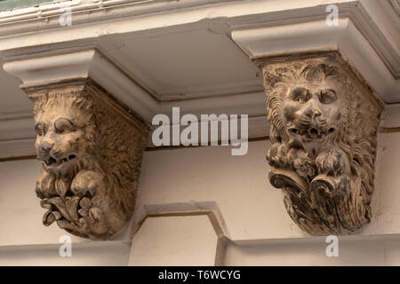 Hockende Löwen dienen als verzierte Schalen, die einen traditionellen maltesischen Balkon mit Gallarien auf einem Gebäude in Valletta stützen. Stockfoto