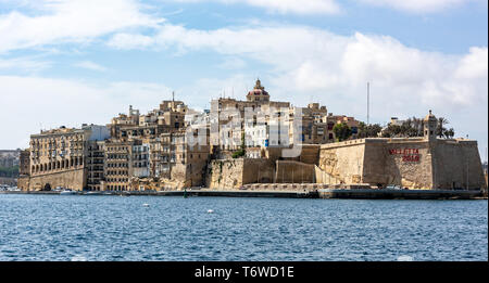 Blick auf Senglea vom Grand Harbour aus, mit der Kuppel und Laterne der St. Phillip's Church, die sich über den traditionellen maltesischen Kalksteingebäuden erhebt Stockfoto