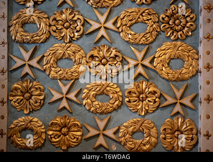 Detail der vergoldeten Motive von Girlanden und maltesischen Kreuzen, die in den weichen maltesischen Kalkstein in der St John's Co-Cathedral, Valletta, gehauen wurden. Stockfoto