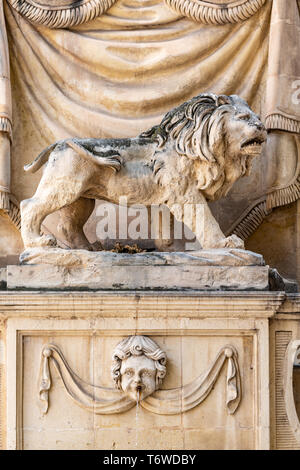 Ein geschnitzter Steinlöwe über einem Wasserbrunnen an der Wand eines Gebäudes in Triq San Gwann, (St. John's Street), in Valletta Stockfoto