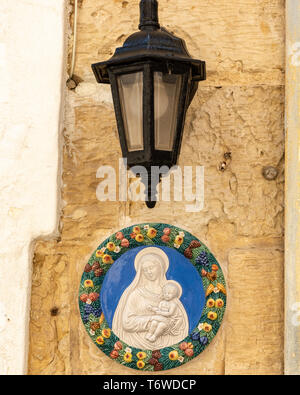 Eine bunte Tafel der Madonna mit Kind unter einer Straßenlampe an einer Wand in Valletta, Malta Stockfoto