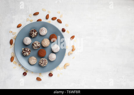 Gesunde organische Energie beißt mit Nüssen, Chia Samen, Mandeln, Kokos cheeps und getrocknete Früchte, rohes Dessert Snacks auf einem Tisch vegan. Flach. Stockfoto