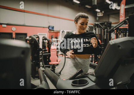 Selbstbewusste Frau Ausübung auf Laufband im Fitnessstudio Stockfoto