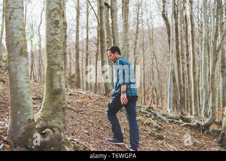 Seitenansicht eines Mannes Wandern in Wald in einem suny Tag Stockfoto