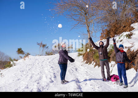 Drei Leute das Werfen mit Schneebällen und stehen auf einer überdachten Gateway Stockfoto