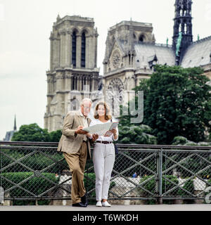 Paar mittleren Alters Touristen an den Stadtplan vor der Kathedrale Notre-Dame de Paris auf der Suche vor dem Brand vom 15. April 2019, Paris, Frankreich, Europa, Stockfoto