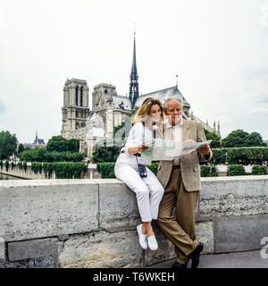 Paar mittleren Alters Touristen an den Stadtplan vor der Kathedrale Notre-Dame de Paris auf der Suche vor dem Brand vom 15. April 2019, Paris, Frankreich, Europa, Stockfoto