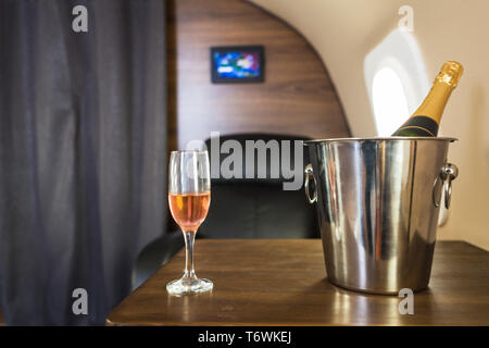 Ein Glas Champagner im Inneren eines privaten Jet. Fliegen erster Klasse Stockfoto