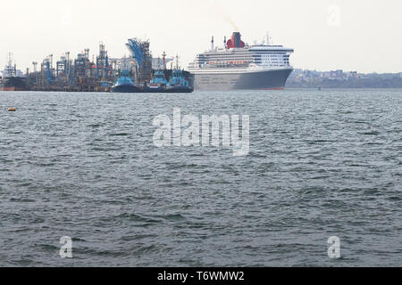 Der Riese, Flaggschiff der Cunard Line, MS Queen Mary 2, dampfenden Vergangenheit Das Fawley Ölraffinerie, wie Sie fährt Southampton, gebunden für New York, 28. April 2019. Stockfoto