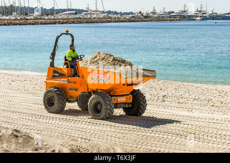 CANNES, Frankreich - April 2019: Muldenkipper transportieren Sand über den Strand in Cannes für den Frühling und Sommer Saison bereit, Stockfoto