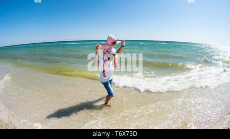 Vater mit einer kleinen Tochter haben Spaß am Strand des Schwarzen Meeres. Urlaub Sommer, Dzharylhach Island, Ukraine Stockfoto